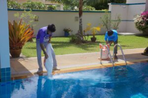 Pool maintenance in action with a technician checking the salt chlorinator system.