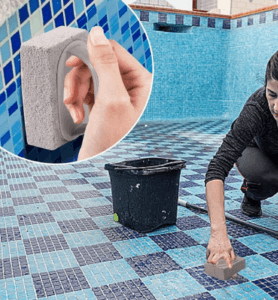 Person using a pumice stone to remove calcium carbonate buildup from pool tiles.