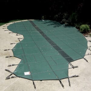 Photo of an irregularly shaped pool covered with a green pool cover secured with straps.